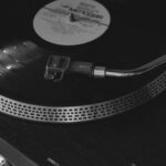 pexels-photo-12302446-12302446 Black and white photo of a retro vinyl player spinning a record, evoking nostalgia.