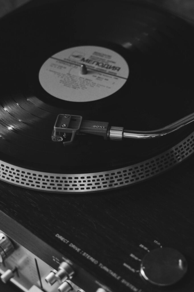 Black and white photo of a retro vinyl player spinning a record, evoking nostalgia.